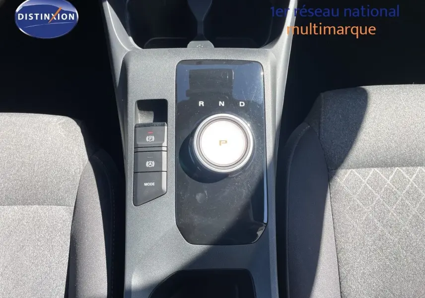 Vue plongeante sur la console centrale du MG3 2025 en tissu gris, avec sélecteur rotatif de boîte auto et boutons de contrôle.