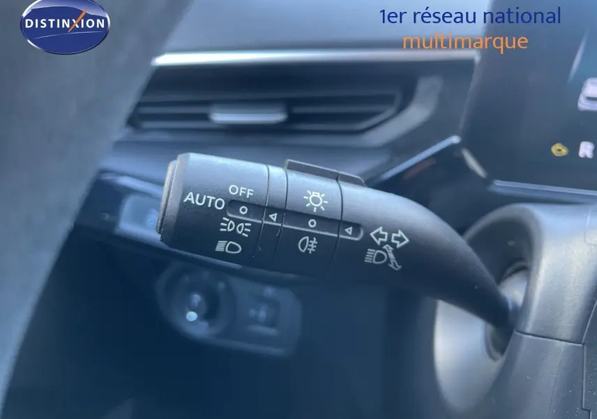 Gros plan sur la commande des feux au volant d’un MG3 Dover White 2025, intérieur noir avec tableau de bord moderne.