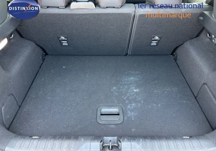 Coffre ouvert vu de l'arrière d'un Ford Puma blanc 2022, montrant l'espace de chargement et les dossiers arrière rabattus.