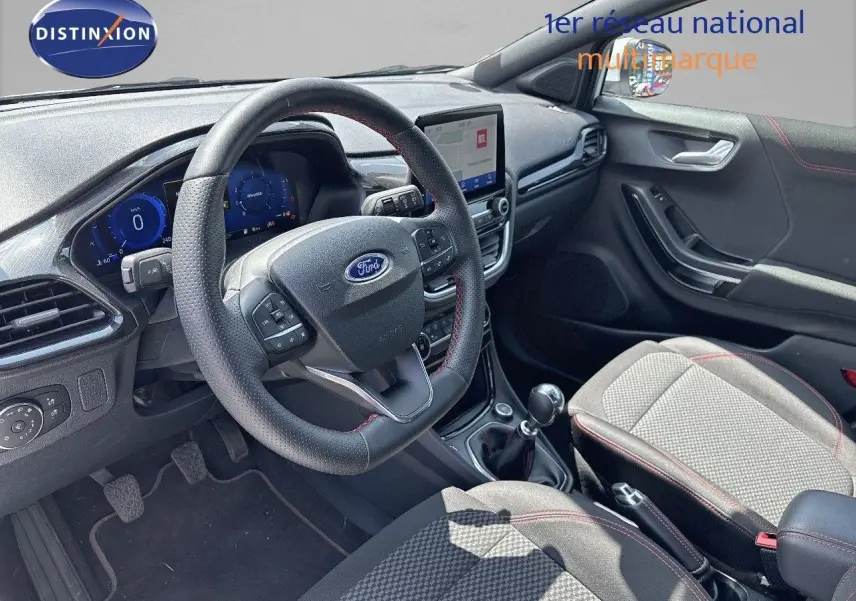 Vue intérieure côté conducteur du Ford Puma blanc 2022, mettant en valeur le volant multifonction et la console centrale avec écran tactile.