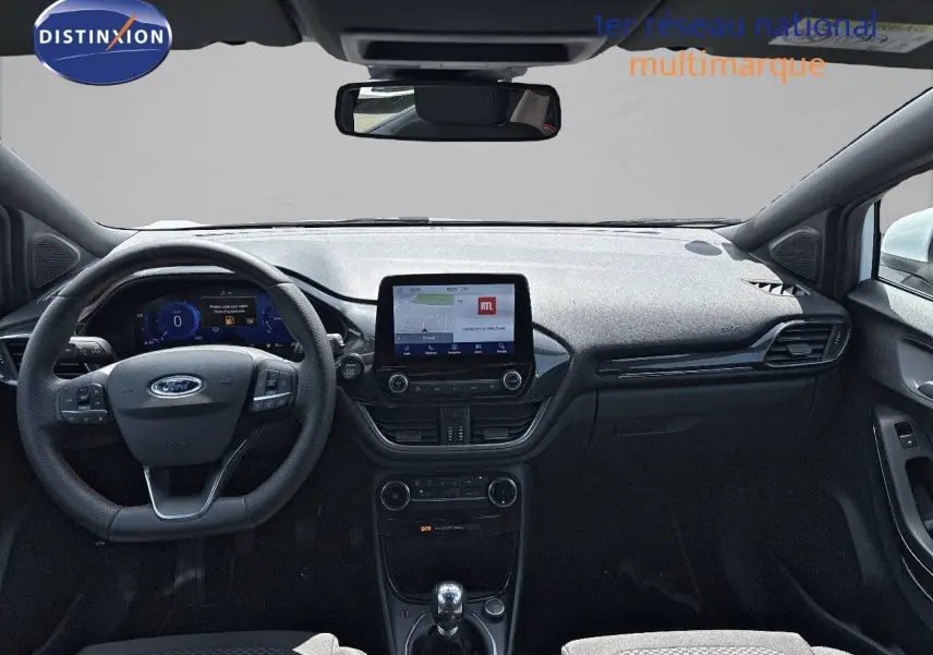 Vue intérieure frontale du tableau de bord noir du Ford Puma blanc 2022 avec écran tactile et volant multifonction.