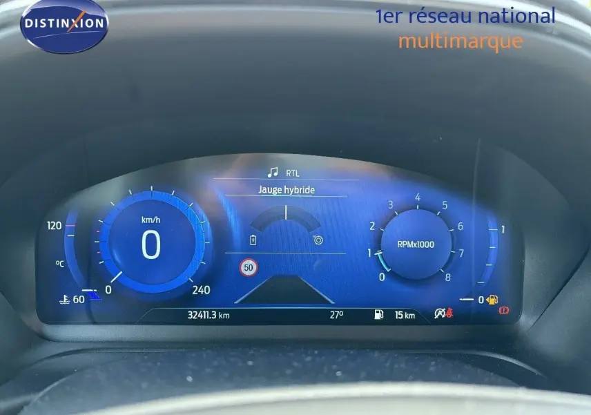 Tableau de bord numérique bleu du Ford Puma 2022 affichant vitesse, compte-tours et jauge hybride à l'arrêt.