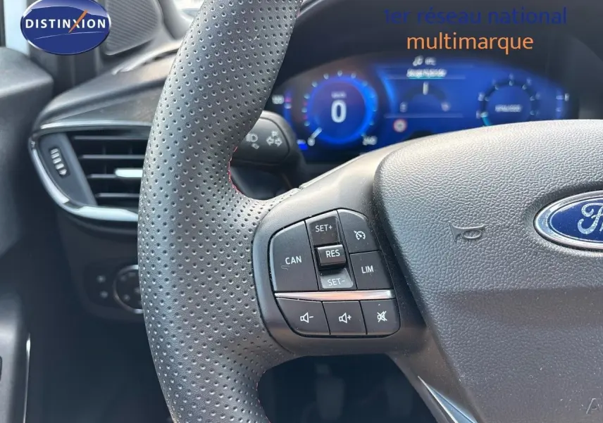 Gros plan sur le volant perforé et les commandes de régulateur du Ford Puma blanc, tableau de bord numérique en arrière-plan.