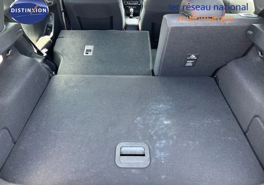 Vue sur le coffre du Ford Puma blanc 2022 avec banquette arrière droite relevée et gauche rabattue, montrant l'espace modulable.