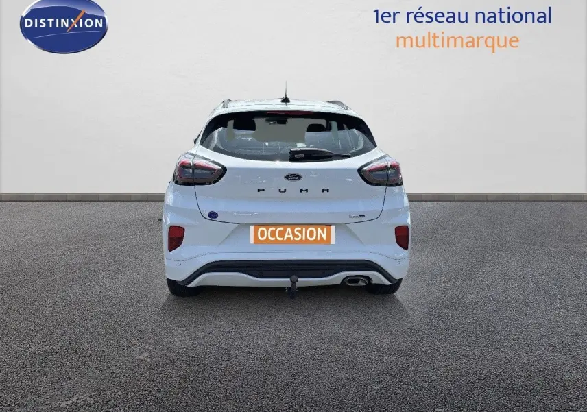 Vue arrière d'une Ford Puma blanche 2022 avec attelage et feux arrière LED, stationnée sur sol gris.