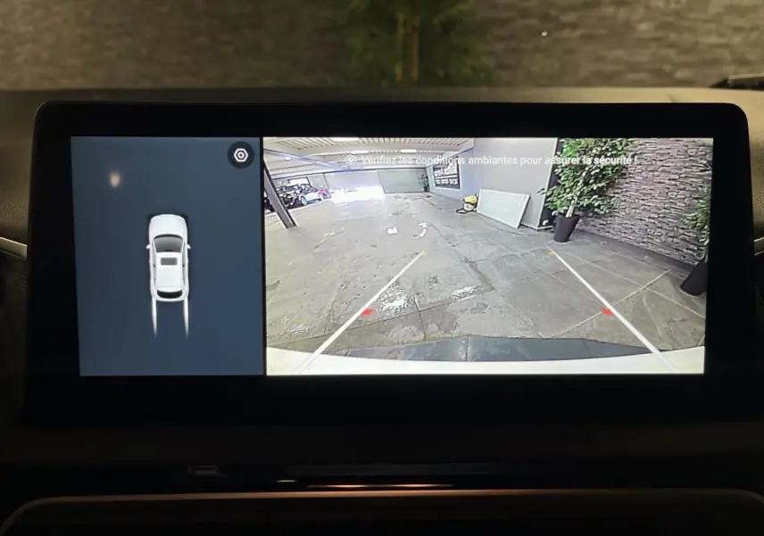 Écran de caméra de recul et vue aérienne du MG3 blanc 2024, montrant l'arrière du véhicule en stationnement.