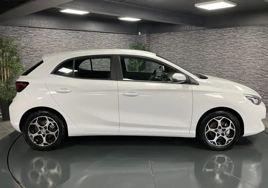 Profil côté gauche d'une MG3 1.5 Hybrid+ 195 Comfort blanche, avec jantes alliage et intérieur noir visible.