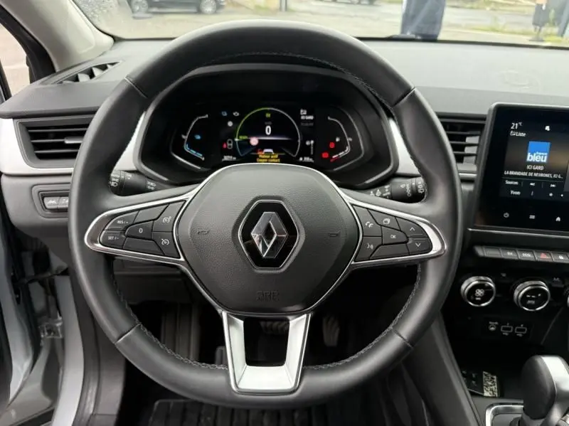 Vue intérieure centrée sur le volant cuir du Renault Captur E-Tech 145 Zen 2022 avec tableau de bord numérique et écran tactile.