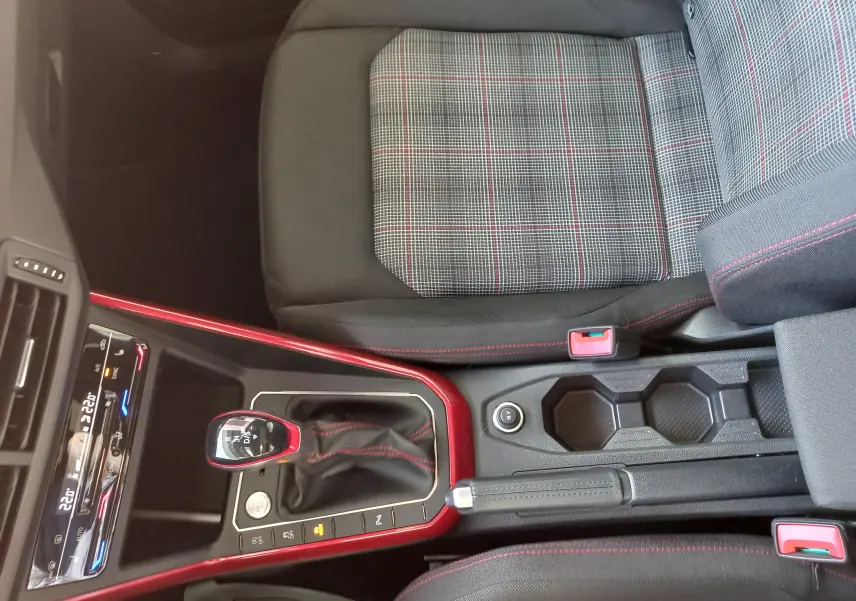 Vue intérieure centrée sur la console centrale et siège avant droit à motif écossais de la Volkswagen Polo GTI 2024.