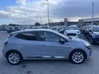 Profil côté gauche d'une Renault Clio V gris métal 2025, version DCI 100 Evolution, garée en extérieur.