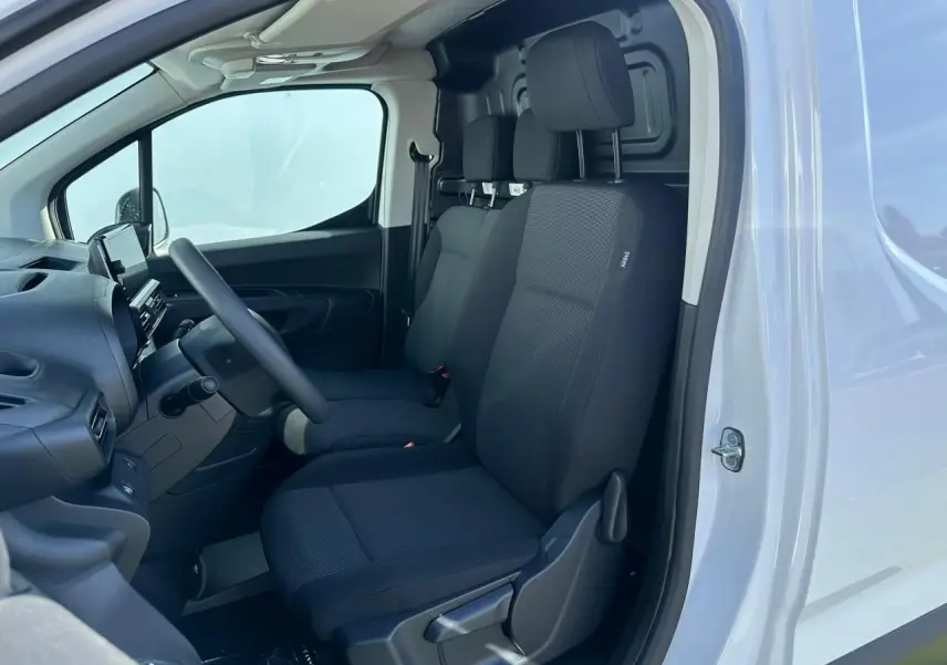 Vue intérieure côté gauche du Citroën Berlingo blanc Icy, montrant les sièges tissu noirs et le tableau de bord.