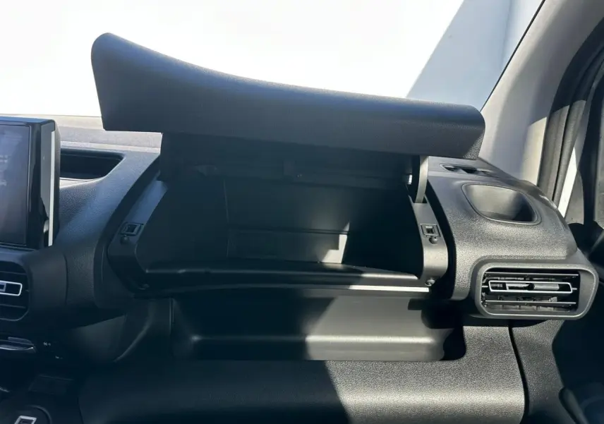 Vue intérieure côté passager du Citroën Berlingo blanc Icy, avec boîte à gants ouverte et tableau de bord noir.