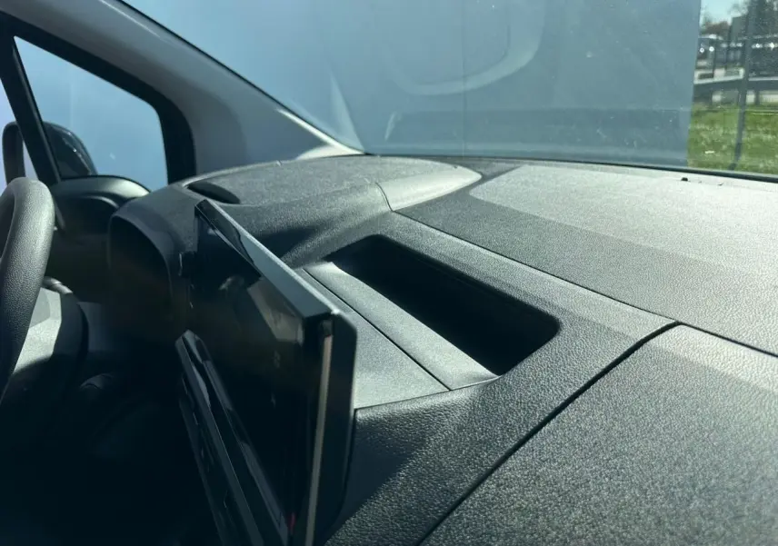 Vue intérieure du tableau de bord noir texturé du Citroën Berlingo III blanc, avec écran tactile déployé côté conducteur.