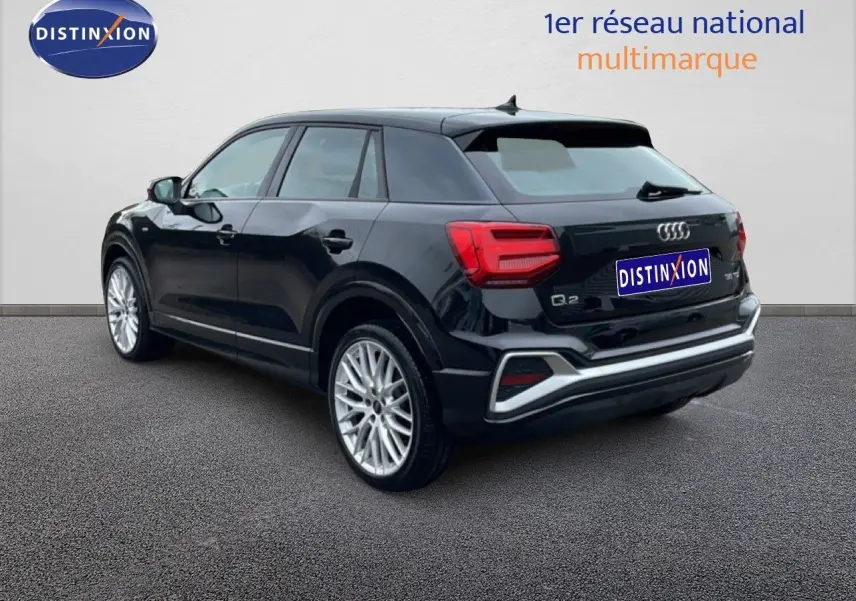 Audi Q2 noir mito métal vue 3/4 arrière droit, avec jantes alliage et feux arrière LED distinctifs.