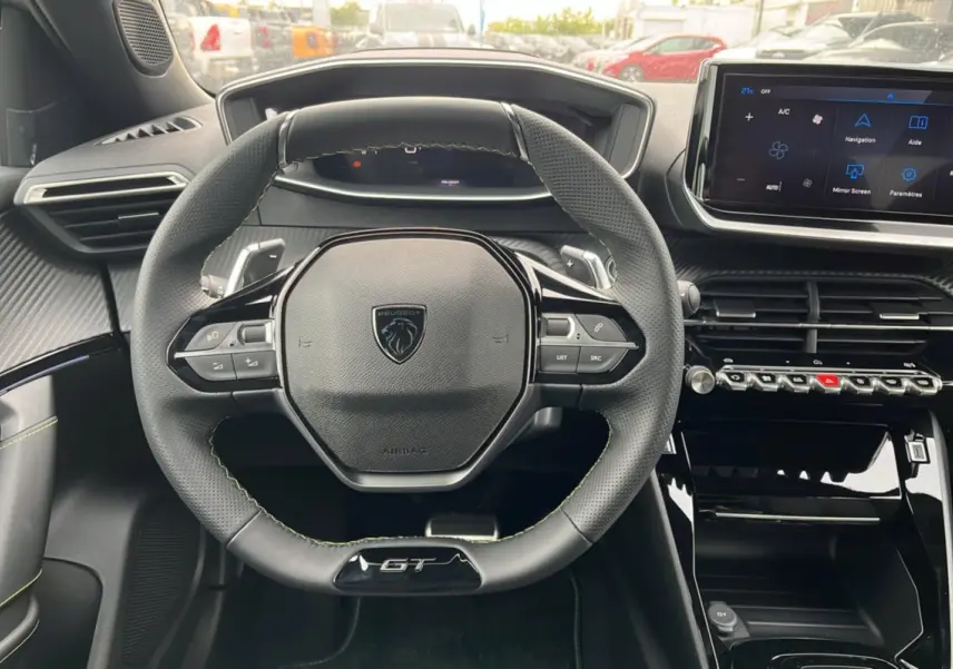 Vue intérieure centrée sur le volant cuir GT et le tableau de bord avec écran tactile du Peugeot 2008 Hybrid 145.