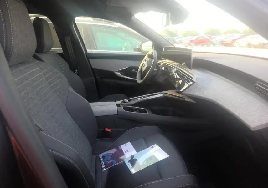 Vue intérieure côté conducteur du Peugeot 5008 gris foncé, mettant en valeur le tableau de bord et l’écran incurvé panoramique.