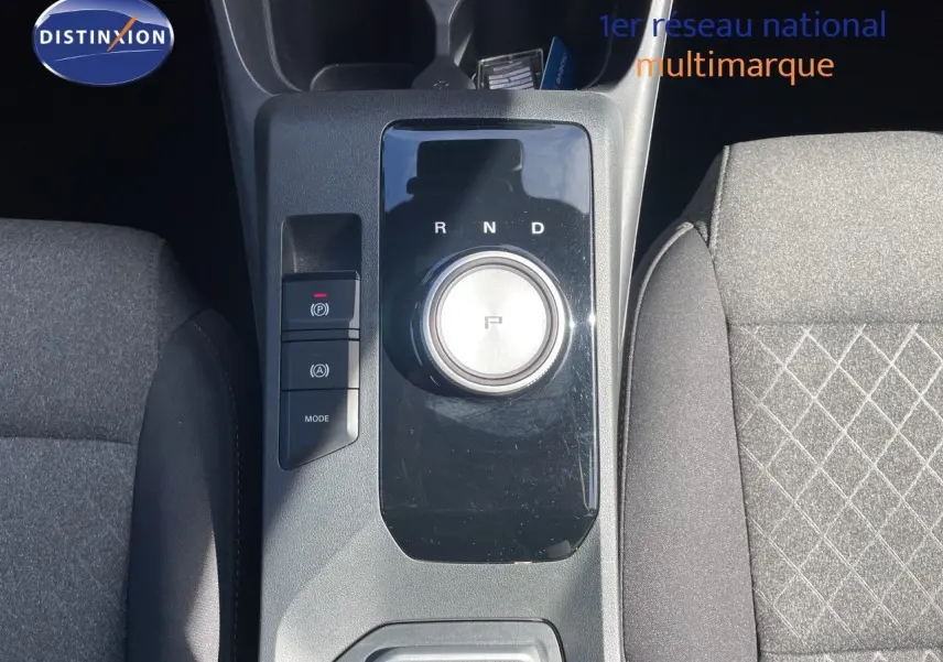 Vue plongeante sur la console centrale du MG3 2024 Pebble Black, mettant en valeur la molette de boîte auto et les sièges tissu gris.
