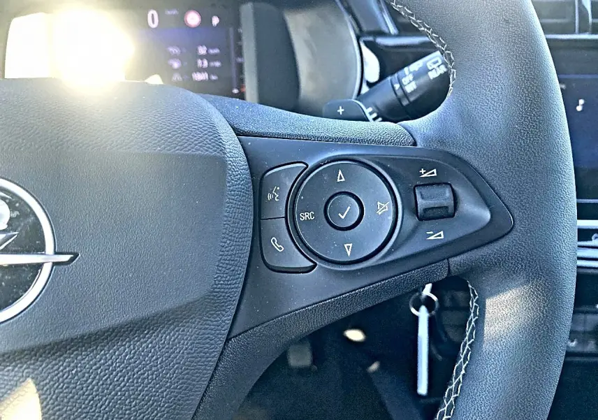 Gros plan sur le volant noir multifonction de l'Opel Corsa 2025 avec commandes audio et téléphone intégrées.