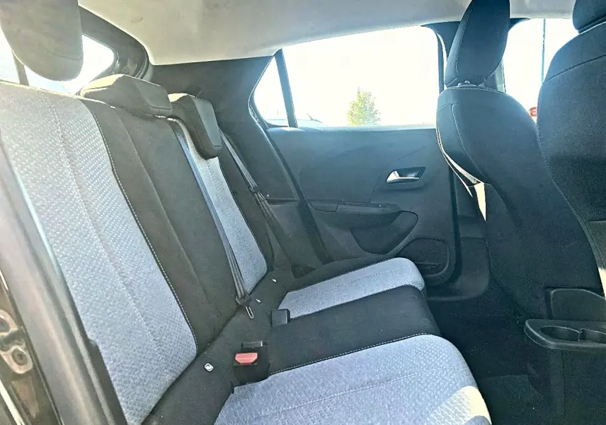 Vue intérieure arrière côté gauche de l’Opel Corsa 2025, sièges tissu bicolore noir et gris, banquette 3 places.