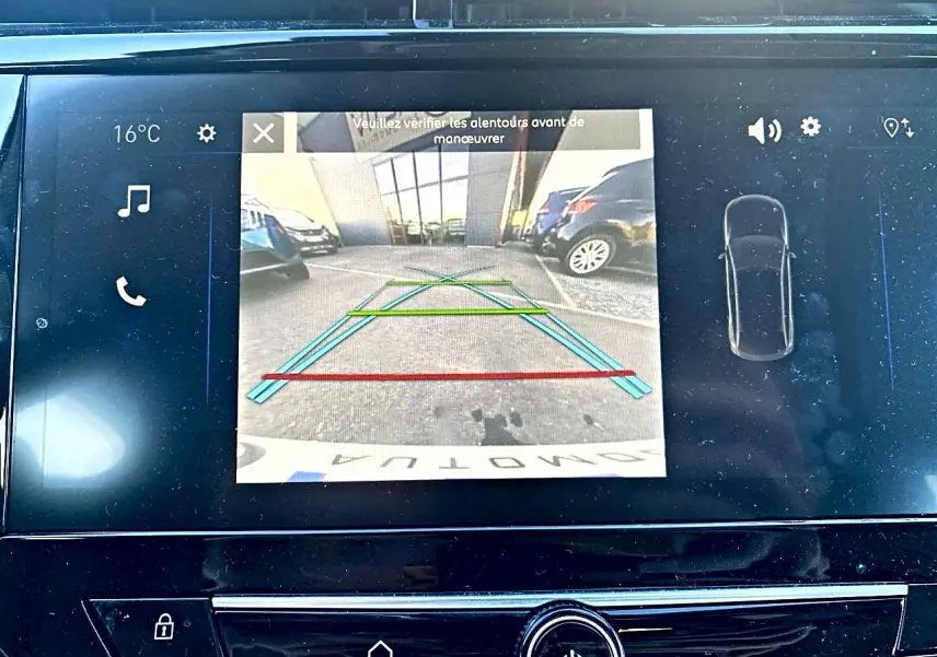 Écran tactile de recul de l’Opel Corsa noire, affichant la caméra arrière avec lignes de guidage colorées.