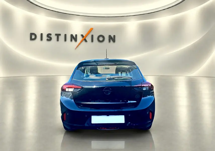 Vue arrière d'une Opel Corsa noire 2025 dans un showroom lumineux avec logo Distinxion en arrière-plan.