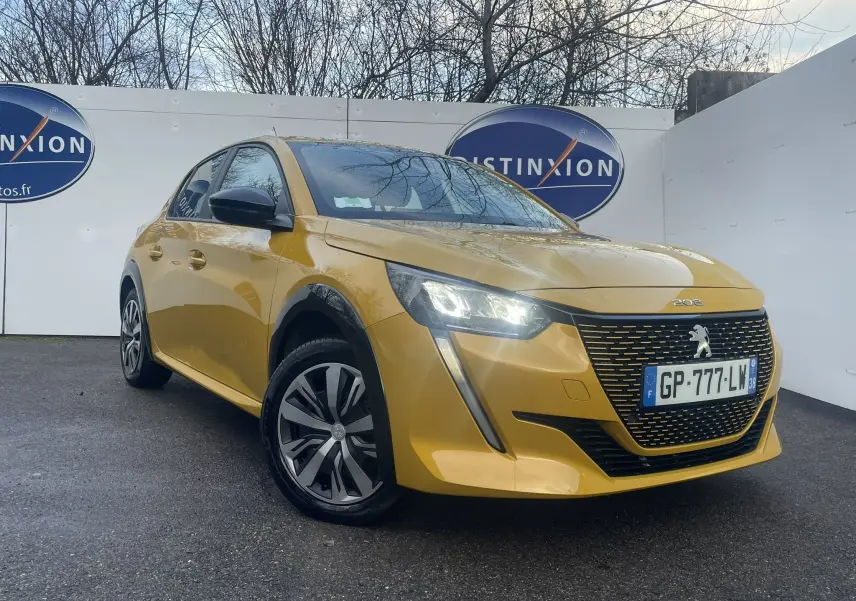 Peugeot 208 II électrique jaune vue en 3/4 avant droit avec phares allumés et calandre noire distinctive.