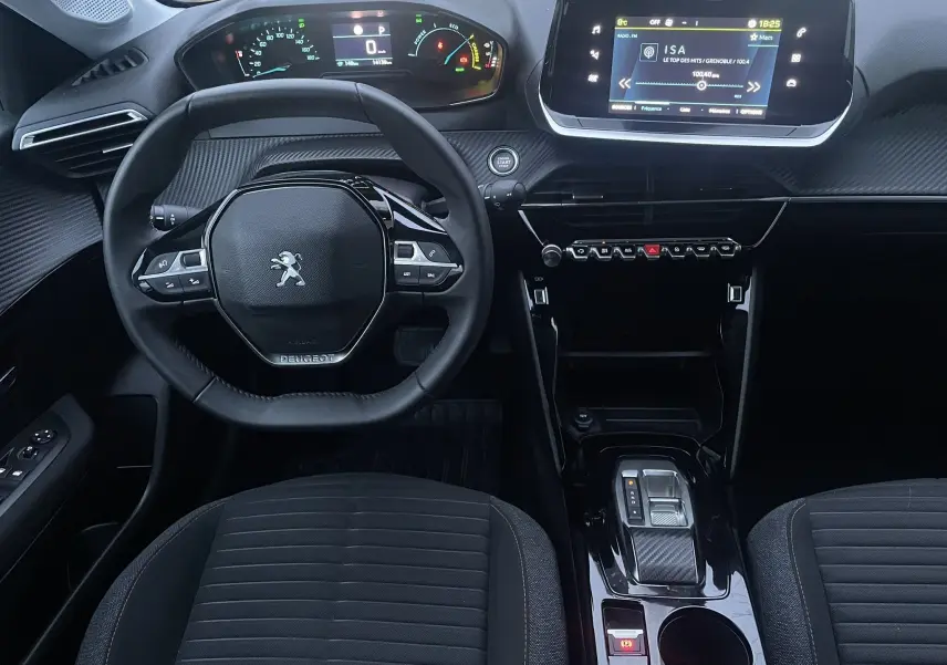 Vue intérieure avant du tableau de bord et volant de la Peugeot 208 II électrique 2023 avec écran tactile et commandes au volant.