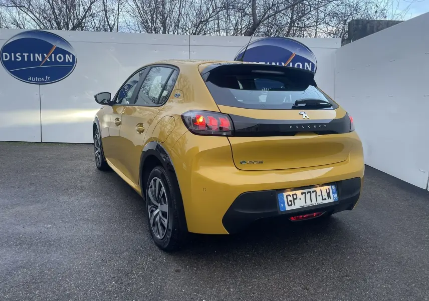Peugeot 208 II électrique jaune vue en 3/4 arrière droit, avec feux arrière allumés et logo e-208 visible.
