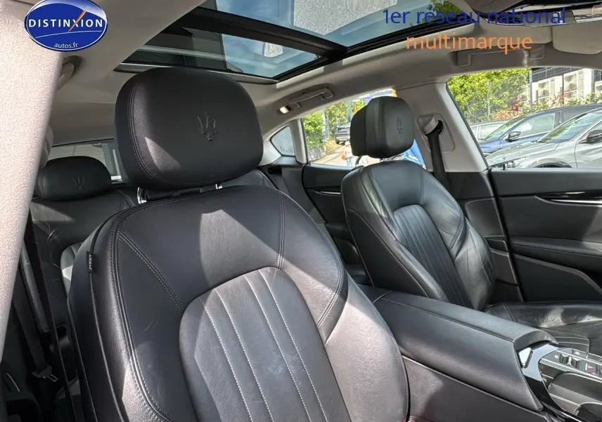 Intérieur cuir noir de Maserati Levante 2017 vu côté droit avec toit panoramique et accoudoir central.