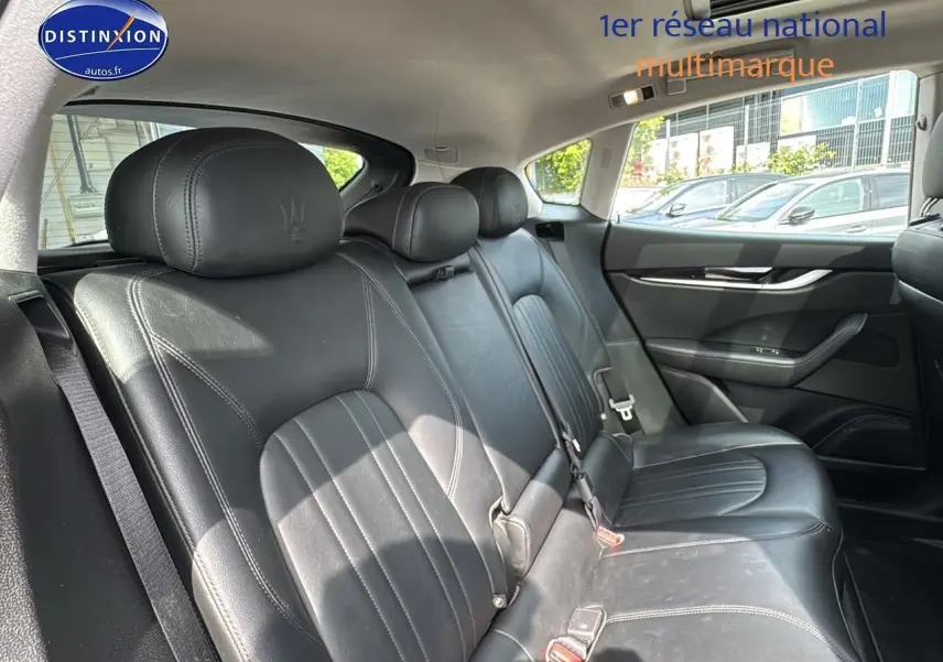 Vue latérale droite de la banquette arrière en cuir noir avec appuis-tête Maserati embossés sur un Levante gris.