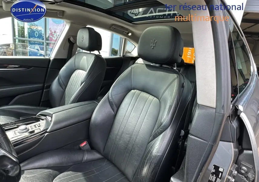 Intérieur cuir noir de la Maserati Levante 2017, vue côté droit sur les sièges avant et accoudoir central.