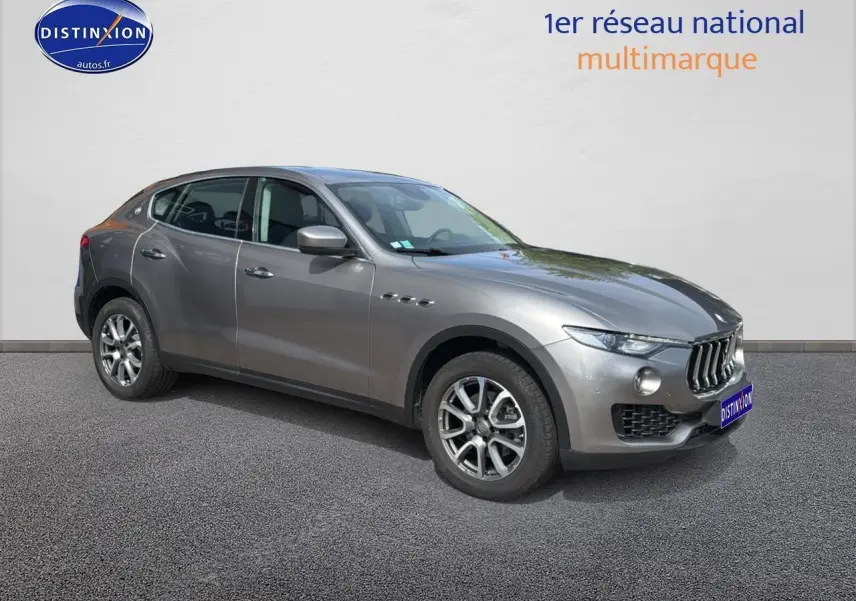 Maserati Levante gris en 3/4 avant droit, mettant en valeur sa calandre chromée et ses jantes alu distinctives.