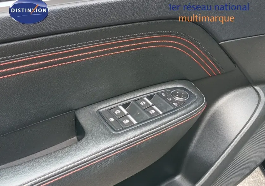 Gros plan sur la garniture noire avec surpiqûres rouges et commandes des vitres côté conducteur du Renault Arkana noir 2021.