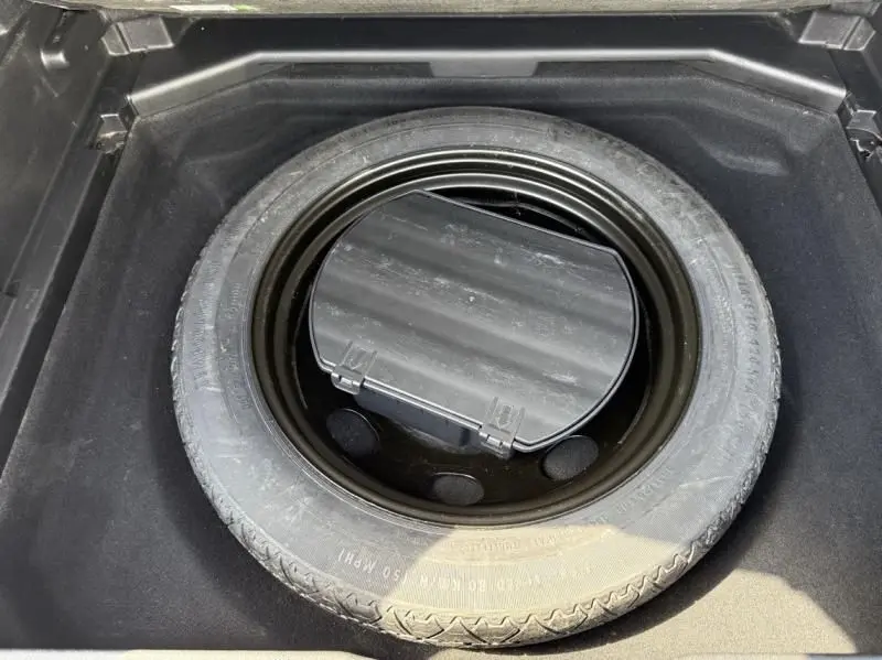 Roue de secours noire vue de dessus dans le coffre d'un Peugeot 3008 1.2 Pure Tech 130 Allure noir de 2018.