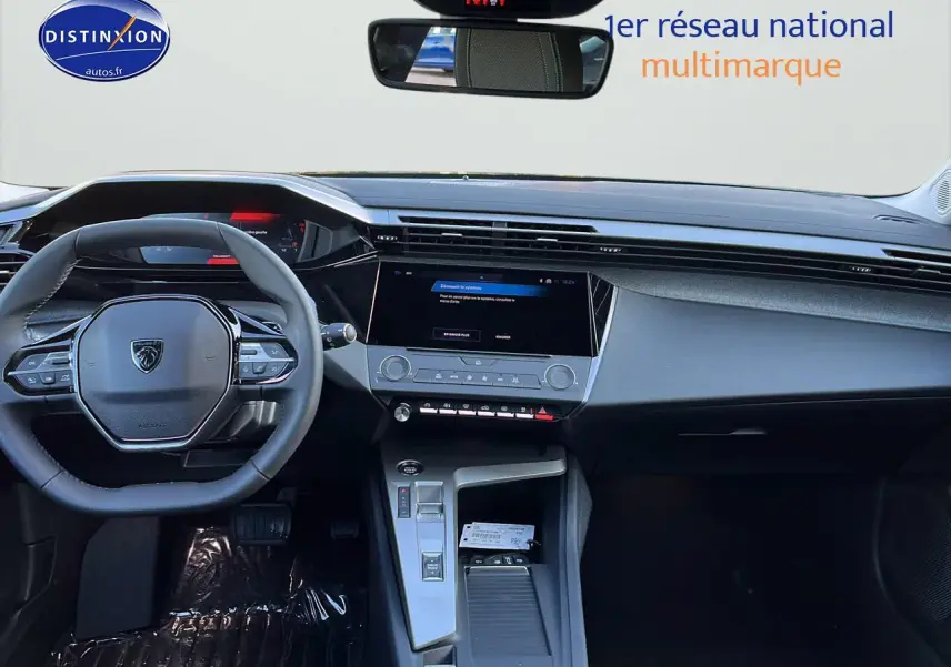 Intérieur de la Peugeot 308 SW 2025 noir perle, vue frontale sur le tableau de bord et volant multifonction.