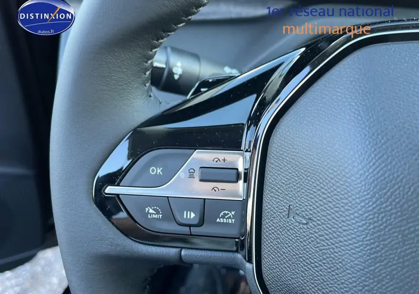 Gros plan sur les commandes au volant côté gauche d'une Peugeot 308 SW 2025 noir perle, soulignant les boutons multifonctions.