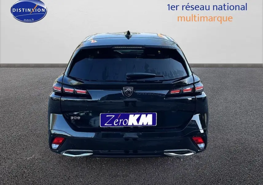 Vue arrière d'une Peugeot 308 SW noire perle avec feux arrière LED et double sortie d'échappement chromée.