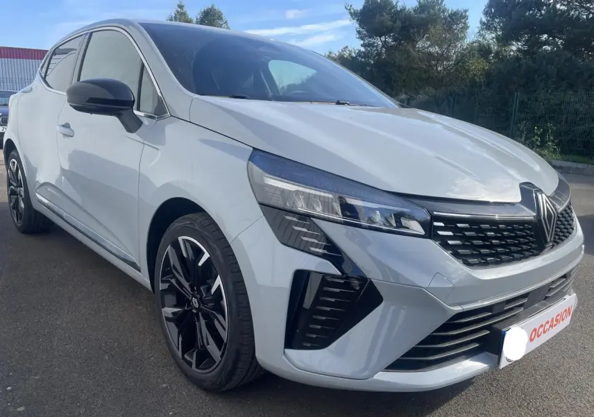 Renault Clio gris Rafale vue 3/4 avant droit avec jantes alliage noires et calandre marquée Renault.