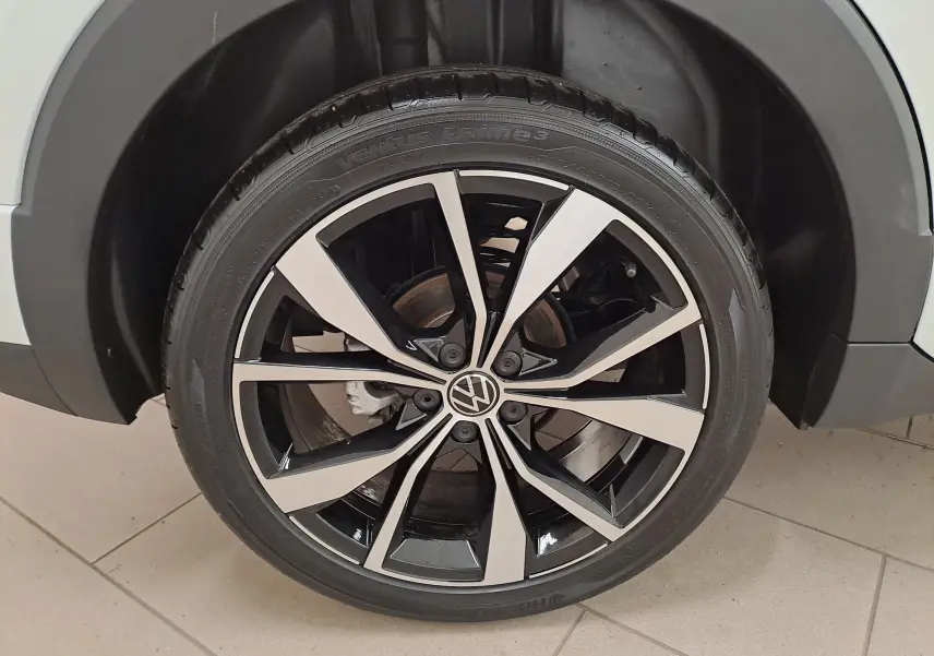 Gros plan sur la jante alliage bicolore noire et argent du Volkswagen T-Cross blanc Pur 2025 version R-Line.