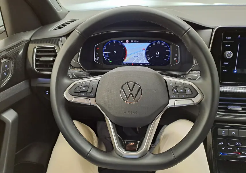 Vue intérieure centrée sur le volant noir du Volkswagen T-Cross 1.0 TSI R-Line Edition 2025 avec tableau de bord numérique.