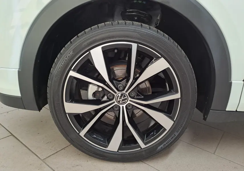 Vue 3/4 arrière droite du Volkswagen T-Cross blanc pur 2025 avec feux LED distinctifs et jantes alliage R-Line.