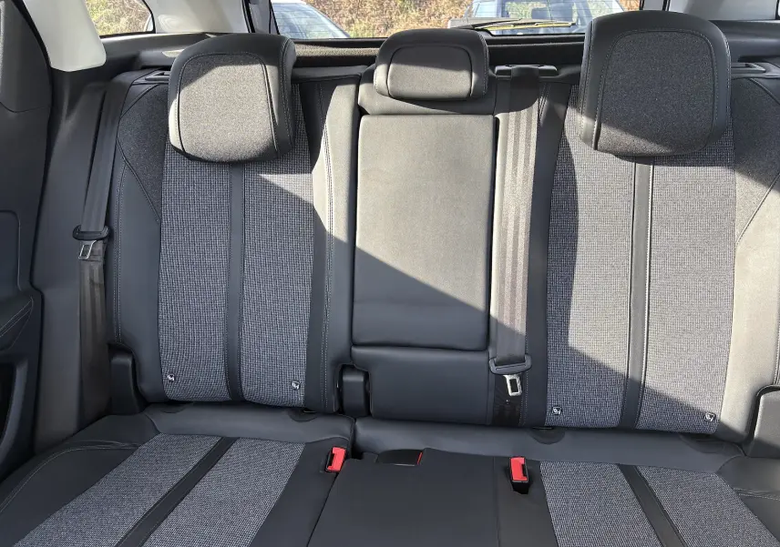 Vue intérieure sur la banquette arrière du Peugeot 3008 2019, tissu gris et cuir noir avec trois appuie-têtes.