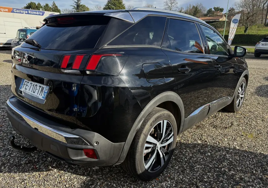 Vue 3/4 arrière droite d'un Peugeot 3008 noir 2019 avec feux arrière à griffes et attelage de remorque visible.