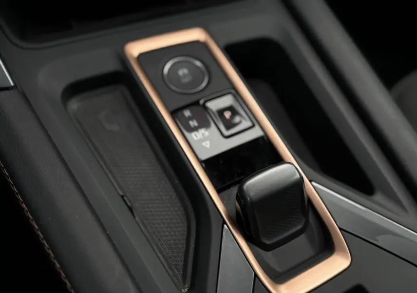 Gros plan sur la console centrale du CUPRA LEON ST 2025, mettant en valeur le levier de vitesses et les finitions cuivrées.