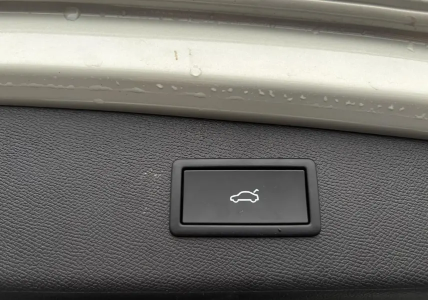 Bouton d'ouverture électrique du hayon sur panneau intérieur gris Taiga d'une CUPRA LEON ST 2025.