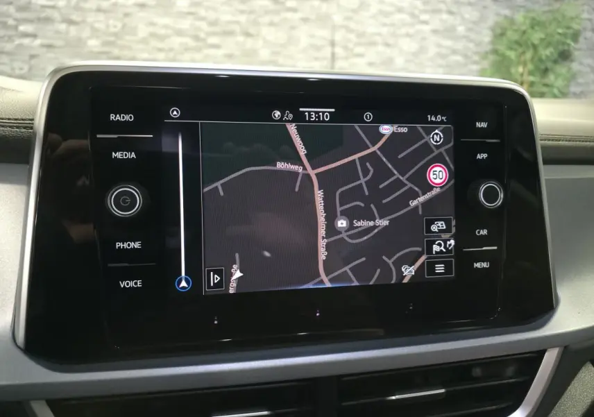 Écran tactile central 8 pouces du Volkswagen T-Roc 2025 affichant la navigation GPS en intérieur noir.