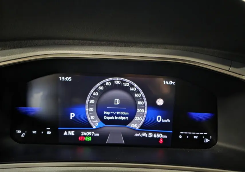 Tableau de bord digital du Volkswagen T-Roc 2025 affichant vitesse, température et autonomie, avec fond bleu.