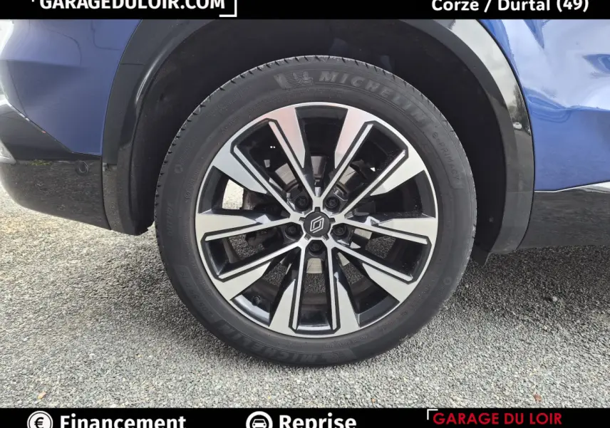 Gros plan sur la roue avant droite du Renault Austral bleu, avec jante alliage bicolore et pneu Michelin.