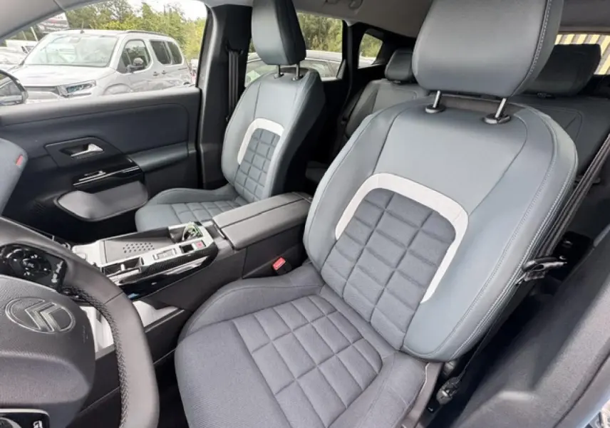 Vue intérieure côté conducteur du Citroën C5 Aircross 2026, sièges bi-matière gris avec accoudoir central.