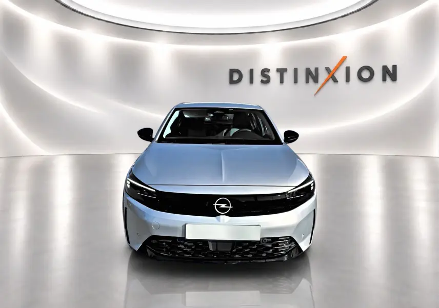 Vue avant d'une Opel Corsa gris clair avec calandre noire brillante, dans un showroom lumineux marqué Distinxion.